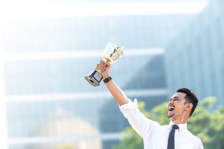 Malay Businessman wins a trophy. Top employee conceptの写真素材