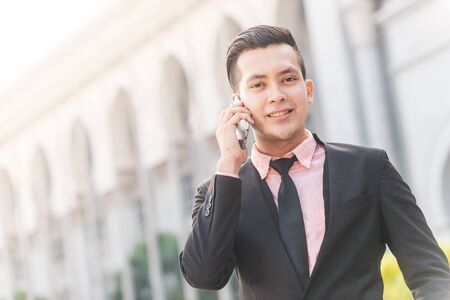 Young Malay Business Man on his Smartphone.