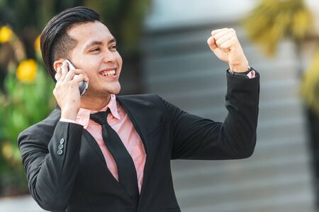 Yes! I am a winner. Young Malay Business Man on his Smartphone.の写真素材