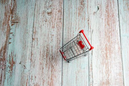 Mini shopping trolley on a wooden background