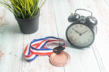 Sport Medal and alarm clock on wooden background. Winning Time conceptの写真素材