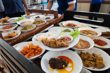The famous Nasi Padang in Indonesia. Rice is served with many dishes like chicken, beef, mix...