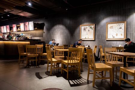 Malaysia, Circa 2019 - Malaysian students studying at Starbucks cafe at night. Starbucks Corporation is an American coffee company and coffeehouse chain.のeditorial素材