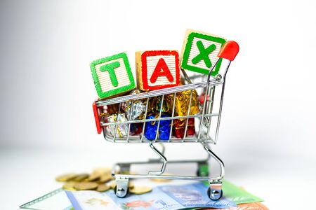 Sales Tax Concept - US Dollars, Shopping cart, Calculator on white background. Shallow depth of field.の写真素材
