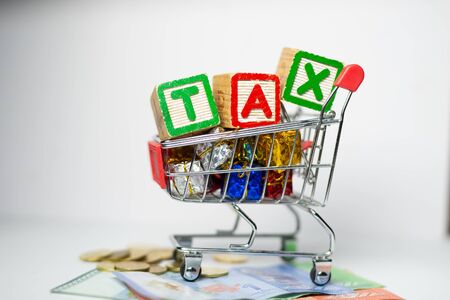 Sales Tax Concept - US Dollars, Shopping cart, Calculator on white background. Shallow depth of field.の写真素材