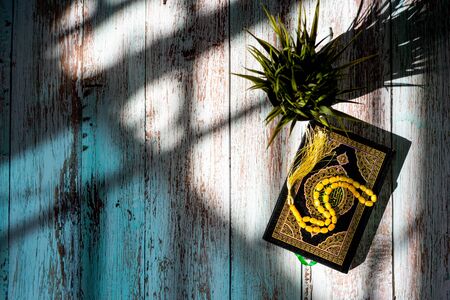 Holy Quran on a wooden table. Ramadan is coming. Shallow depth of field. Shadow and lightの写真素材