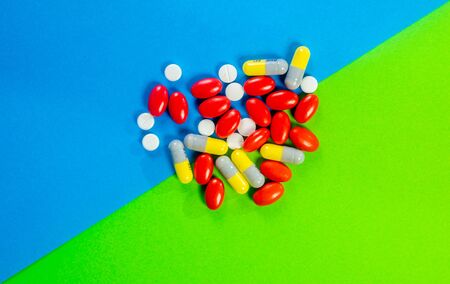Pills, drugs on green and blue background. Healthcare concept. Shallow depth of field, soft focus