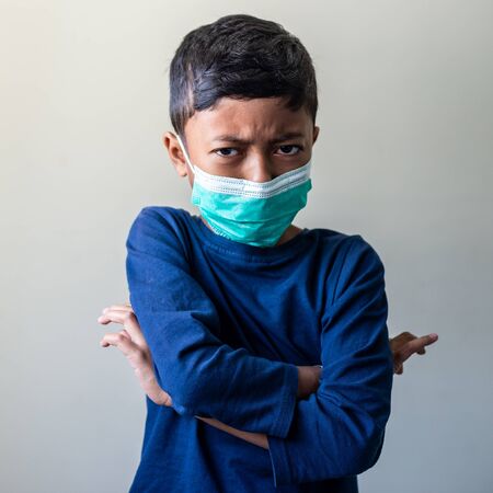 Angry Sick Muslim Kid with surgical mask. Precaution during Covid-19 Coronavirus scareの写真素材