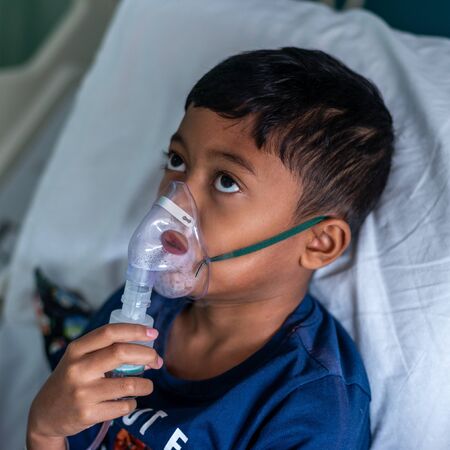 Muslim Boy with his nebuliser. Asthma treatment. Soft focus, shallow depth of fieldの写真素材