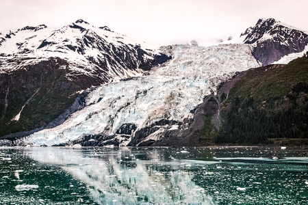 Amazing glacier reflecting in the pure waters of Alaskaの写真素材