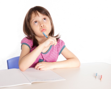 Child at desk with pencils and notebookの写真素材
