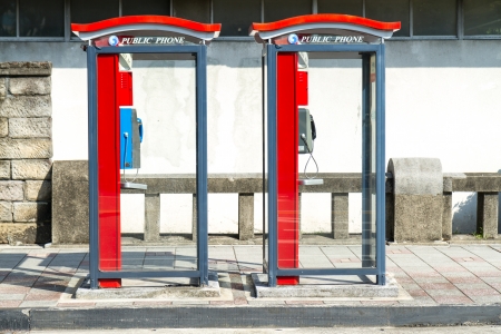 Two telephone booths on a sidewalkの写真素材