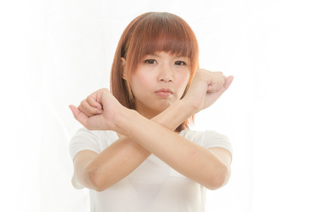 Young Asian woman making stop gesture over white backgroundの写真素材
