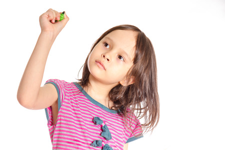 Young girl writing with a green marker on a virtual boardの写真素材