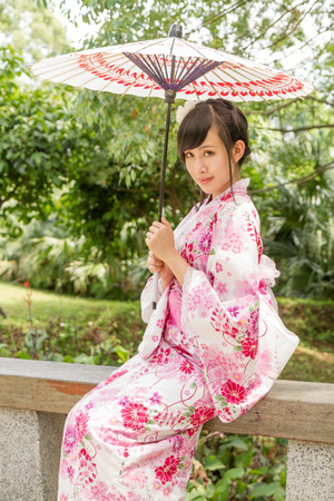Chinese lady wearing kimono in traditional Japanese style gardenの写真素材