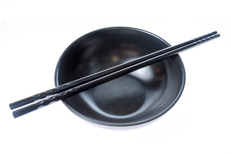 Chinese or Japanese chopsticks on empty black bowlの写真素材