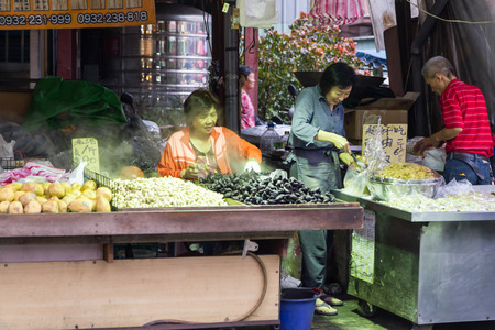 NEW TAIPEI CITY, TAIPEI, TAIWAN. NOVEMBER 2, 2014. Traditional street market in Taiwan with vendor selling water chestnuts.のeditorial素材