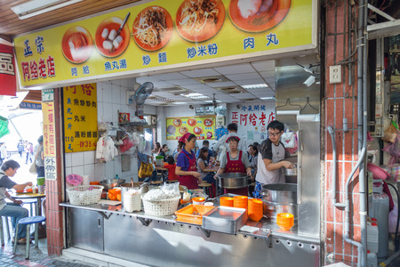 NEW TAIPEI CITY, TAIWAN - SEPTEMBER 11, 2015: A-gei restaurant and shoppers at Danshui shopping area. Danshui is famous for a-gei.のeditorial素材
