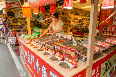NEW TAIPEI CITY, TAIWAN - SEPTEMBER 11, 2015: Chili fish vendors and shoppers at Danshui shopping areaのeditorial素材