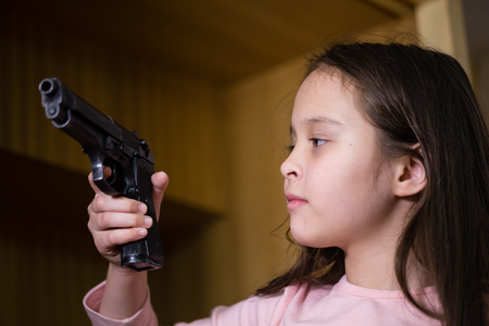 Young child finds pistol in cupboard, gun control conceptの写真素材