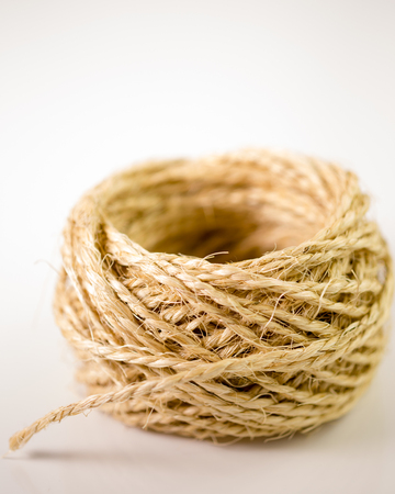 Ball of twine unrravels on white backgroundの写真素材