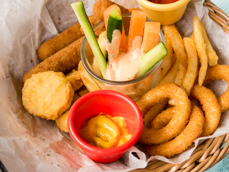 Platter of fried food, cheese sticks, onion rings, chicken nuggetsの写真素材