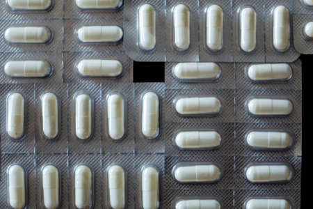 Flat lay shot of tablets in blister pack on black backgroundの写真素材