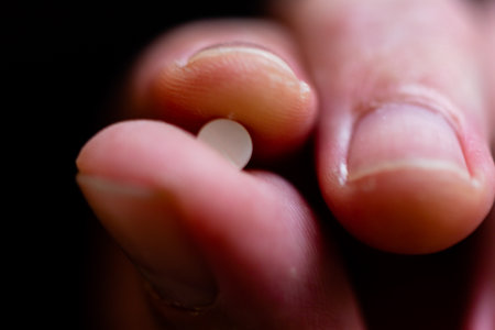 Fingers holding tablet, macro shot