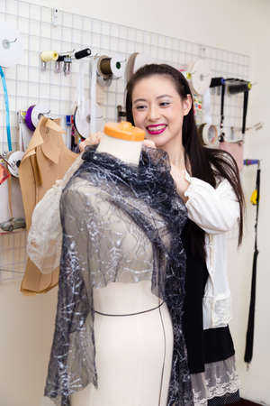 Asian American fashion designer dressing a mannequinの写真素材