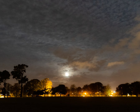A cloudy night sky as the moon struggles to peak throughの写真素材