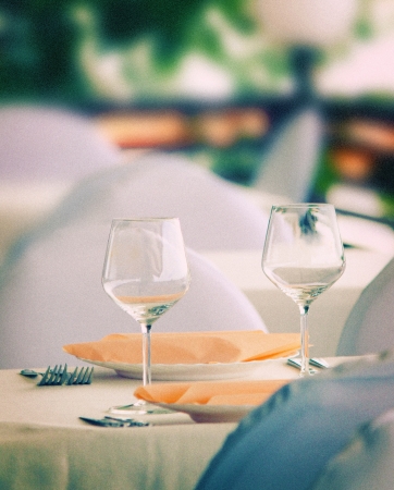 Pair of wineglasses on elegant table setting  Outdoor shot  Toned image, grain addedの写真素材