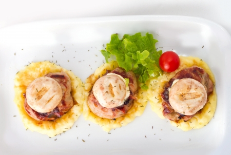 Chicken mignons served on mashed potato with melting butter and grilled mushroomsの写真素材