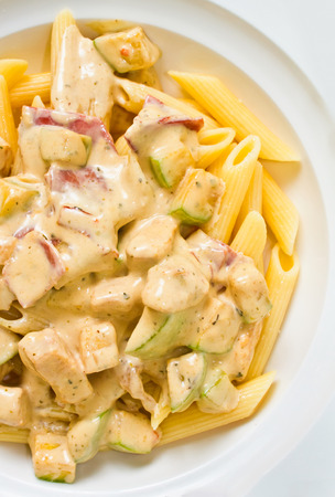 Overhead shot of penne pasta with alfredo sauce, bacon and zucchiniの写真素材