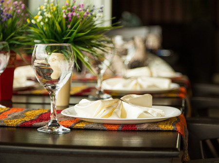Natural light or daylight shot of modern restaurant table set for a lunch. Shallow focus on wine...