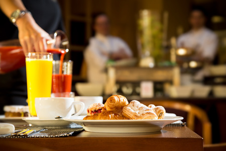 Morning scene of pouring fresh juices at hotel breakfast tableの写真素材