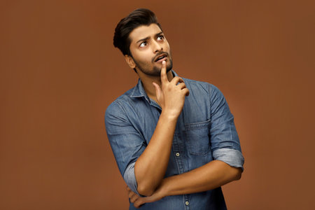 A young man is thinking about something and looking away.の写真素材