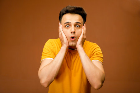 Asian Man with a shocked, surprised, and amazed expression on his face looking at the camera.