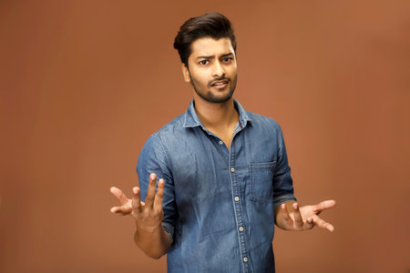 A clueless man raising his hands and looking at the camera.の写真素材