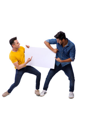 2 best friends holding a blank sign in their hands and pointing towards it.