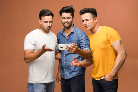 A group of best friends are sad after losing a match while watching a live sports match on their mobile phone.の写真素材