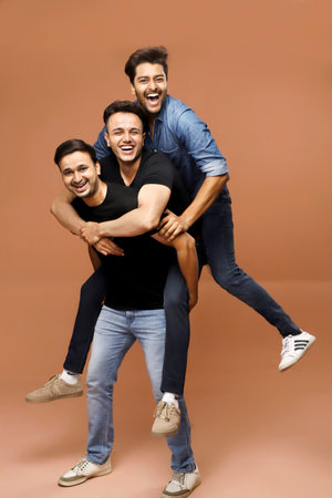 Three young men are having fun while standing and posing in front of the camera.の写真素材