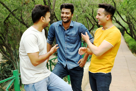 A group of three men are enjoying eating ice cream.