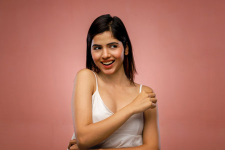 Portrait of young beautiful asian woman with white shirt on pink backgroundの写真素材