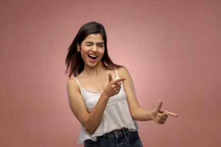 Young asian woman in a white shirt on a pink background.の写真素材