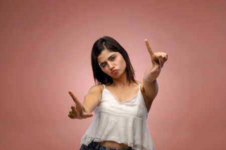 Young asian woman in a white shirt on a pink background.の写真素材