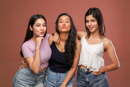Group of young asian women in jeans on a brown background.の写真素材