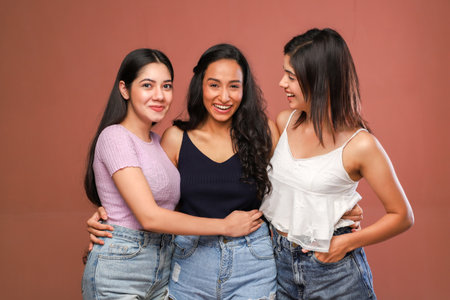 Three young asian women standing together and looking at each other.の写真素材