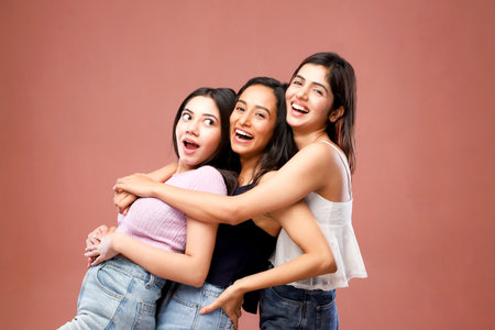 Group of happy young asian women friends having fun together isolated on brown backgroundの写真素材