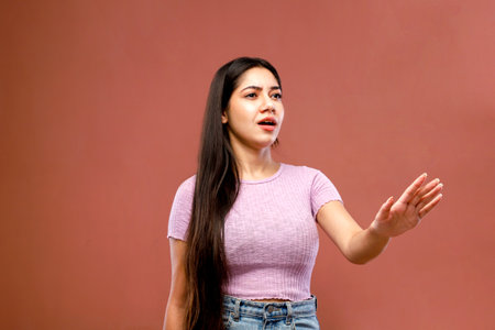 Portrait of a beautiful young woman with long hair standing on a pink backgroundの写真素材