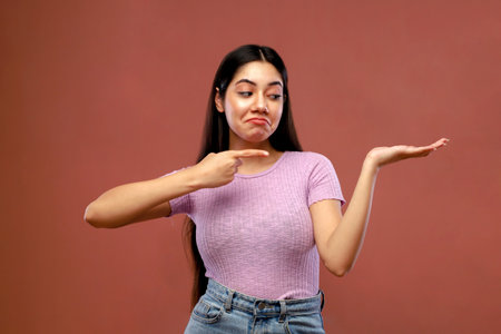 Portrait of a young beautiful asian woman shrugging shouldersの写真素材